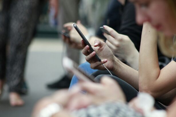 Close-up of people sitting side by side using smartphones, with multiple hands holding mobile devices, illustrating social media and digital connectivity.