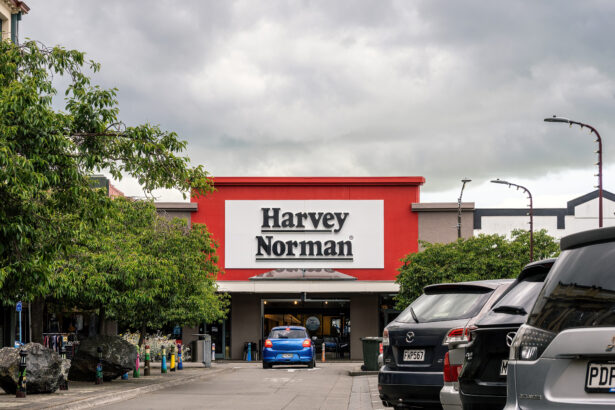 Exterior of a Harvey Norman store with cars parked outside.