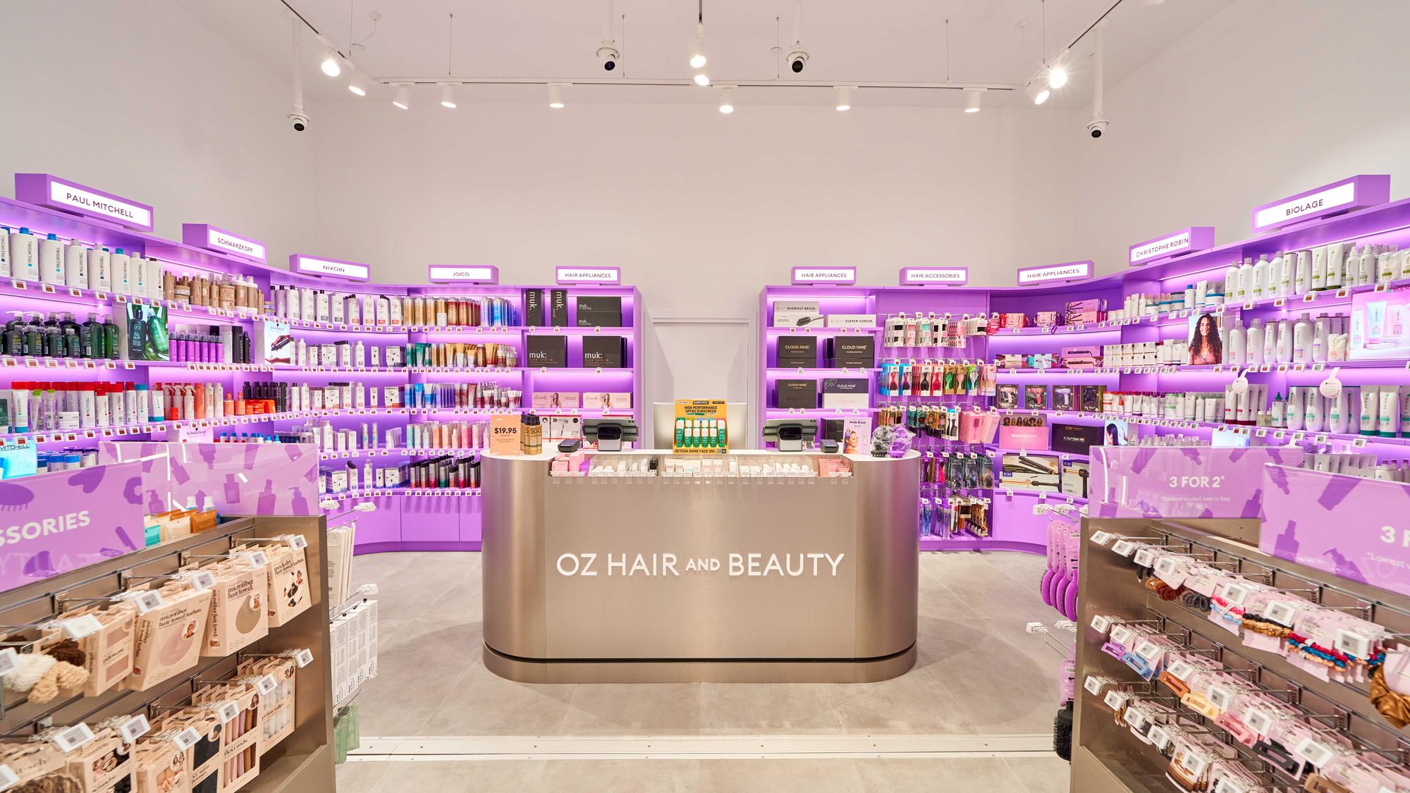 Interior of an Oz Hair and Beauty retail store featuring shelves of haircare products, styling tools and beauty accessories surrounding a central service counter, highlighting the retailer's expansion into physical stores.