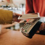 A customer making a contactless payment with a smartphone on an EFTPOS terminal.