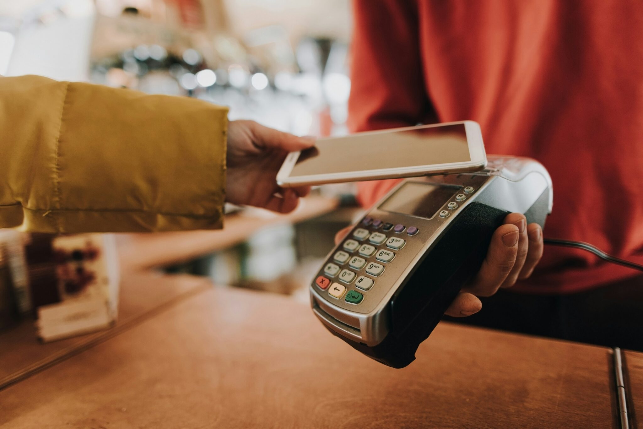 A customer making a contactless payment with a smartphone on an EFTPOS terminal.