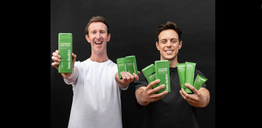Two men holding a range of Two Dudes personal care products.
