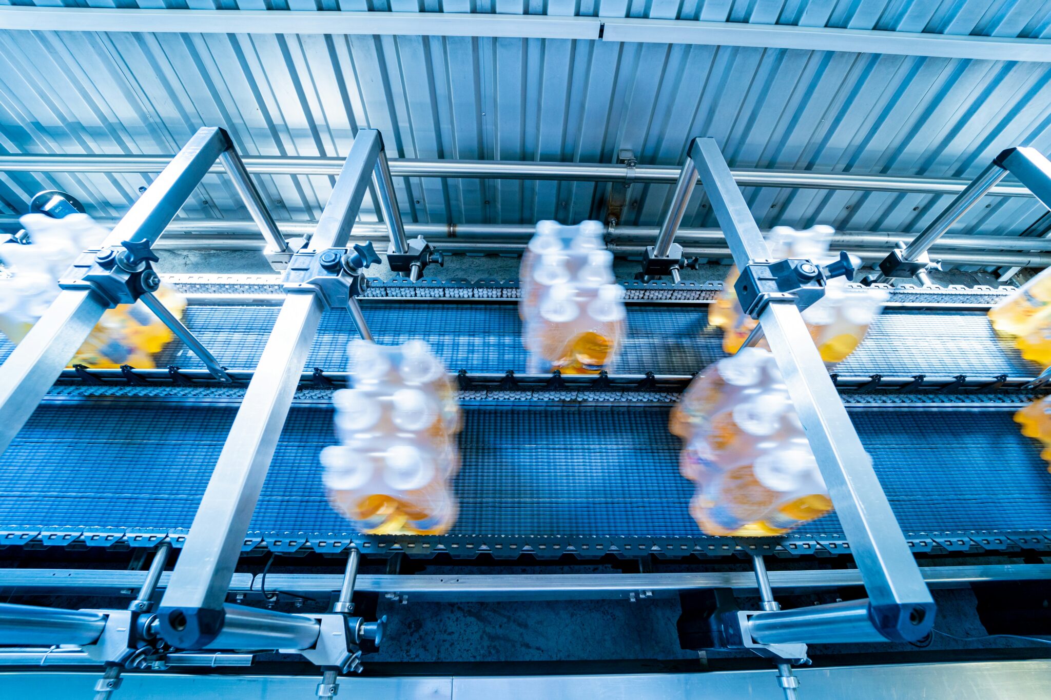Modern strapping and transporting machine or packaging line at beverage plant.